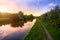 Colorful sunset behind trees with canal and tow path