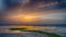 Colorful sunset with cliffs in the water on sea beach