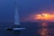 Colorful sunset. Dramatic and Atmospheric landscape. Costa Brava, Spain. Seacoast. Seascape with sailboat. Tourist catamaran.