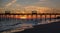 Colorful Sunset at ocean coast with silhouette of pier and photo