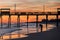 Colorful Sunset at ocean coast with silhouette of pier and photo