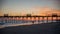 Colorful Sunset at ocean coast with silhouette of pier and photo