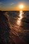 Colorful sunset over beach and seashore waterline of Baltic Sea with peaceful waves in Karwia resort, north Poland, in summer