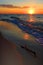 Colorful sunset over beach and seashore waterline of Baltic Sea with peaceful waves in Karwia resort, north Poland, in summer