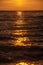 colorful sunset over calm sea beach with dark blue water and dramatic contrasty clouds