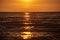 colorful sunset over calm sea beach with dark blue water and dramatic contrasty clouds