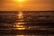 colorful sunset over calm sea beach with dark blue water and dramatic contrasty clouds