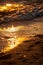 colorful sunset over calm sea beach with dark blue water and dramatic contrasty clouds