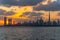 Colorful sunset over the iconic buildings of Dubai. Amazing gray clouds and orange color sky. The modern and luxury cityscape pano