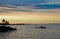 Colorful sunset over lake on a cloudy evening. Seagulls on rocky islets in the water