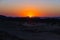 Colorful sunset over the Namib desert, Namibia, Africa. Mountains, dunes and Acacia trees silhouette in backlight. Orange red clea