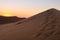 Colorful sunset over the Namib desert, Namibia, Africa. Scenic sand dunes in backlight in the Namib Naukluft National Park