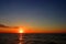 Colorful sunset over the waterline horizon of Baltic Sea with peaceful waves seen from the seaside beach in Karwia resort, north