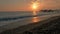 Colorful sunset. Sea view with waves and foam, pier and pebble beach