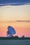 Colorful sunset sky over radiotelescope antenna at astronomy obs