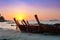 Colorful sunset with Thai traditional longtail boat on the beach