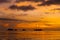 Colorful sunset on a tropical beach. Orange sunset on the ocean. Colorful sunset in the tropics. In the water is a sailing ship.