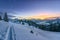 Colorful sunset view from ski track on snowy filed