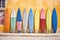 colorful surfboards leaning against a sandy wall