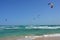 Colorful surfing kites over the emerald ocean vawes