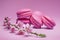 Colorful sweet macarons or macaroons, cherry flavored cookies on pink background with blooming cherry branch near them