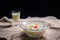 Colorful sweet rice gnocchi in fresh coconut milk in glass bowl on brown tablecloth on blackground. Delicious Thai desserts