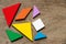 Colorful tangram puzzle wait to develop shape on wood background