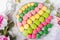 Colorful tasty macaroons on wooden table with flowers, a french sweet delicacy, macaroon texture. Top view