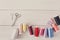 Colorful thread spools and scissors on wooden table flat lay