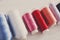 Colorful thread spools on wooden table close up