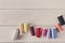 Colorful thread spools on wooden table flat lay