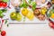 Colorful tomatoes cooking. Bright tomatoes salad ingredients on white marble cutting board and white wooden background, top view