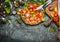 Colorful tomatoes salad preparation with cutting board, plate and cutlery , top view