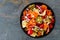 Colorful tortellini pasta salad overhead view on dark slate