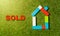 Colorful toy blocks house word Sold written on grass in Real State and Property industry concept