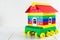 Colorful toy house on wheels on light background. Concept of movement and relocation