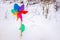 Colorful toy pinwheel on the white snow, background with copy space