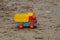 Colorful toy truck on the sand outdoors. Horizontal shot.