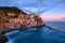 Colorful traditional houses on the rock over Mediterranean sea on dramatic sunset, Manarola, Cinque Terre, Italy