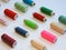 Colorful treads for sewing.Sewing supplies and accessories for needlework- scissors, needles, yellow measuring tape, thread on a t