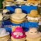 Colorful trendy female summer sun straw hats for sale in beach shop in Dubai. Assortment hats