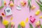 Colorful tulips, birdhouse, watering can wooden heard on pink background