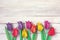 Colorful tulips origami flowers border on white wooden table