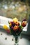 Colorful tulips in a vase on as a valentines gift. Bouquet of tulips lying on windowsill. Top of view. Natural background. Concept