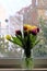 Colorful tulips in vase on windowsill, cheerful home decor