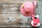 A colorful ukulele and pink hat lay down on the vintage wood background.