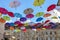 Colorful umbrellas in the blue sky above old street in Carouge town, neighborhood of Geneva, Switzerland,