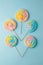 Colorful unicorn rainbow color meringue lollipops candy on pale on blue background. Flat lay. Summer sweet abstract Minimal