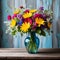 A colorful vase filled to the brim with fresh flowers perched atop a rustic wooden table displays a burst of blooms.