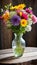 A colorful vase filled to the brim with fresh flowers perched atop a rustic wooden table displays a burst of blooms.